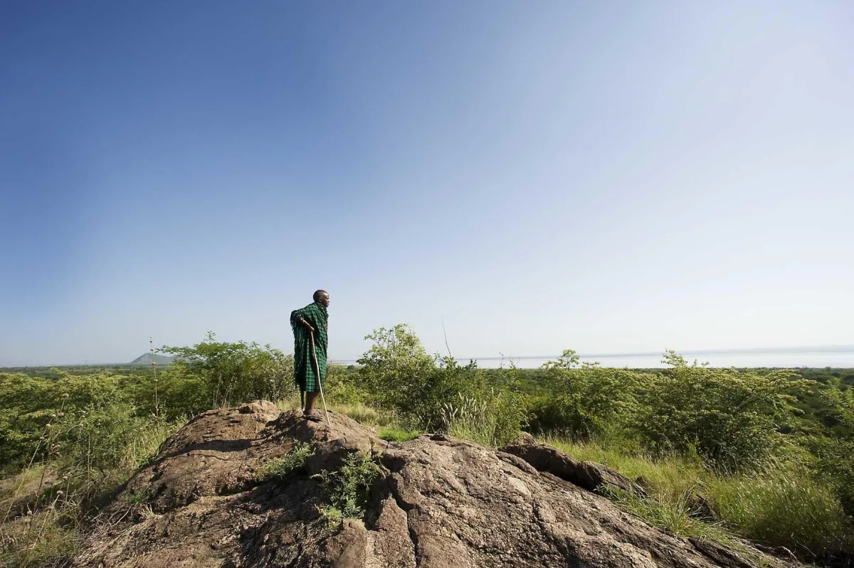 Lake Burunge Tented Lodge – Maasai guide on a rocky outcrop above Lake Burunge near Tarangire National Park