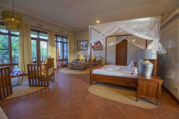 Four-poster bed in a guest cottage at Ngorongoro Coffee Lodge