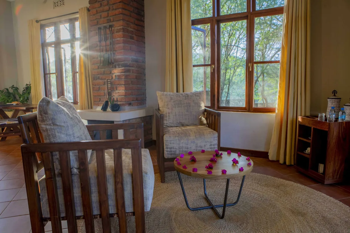 Cottage sitting area with fireplace at Ngorongoro Coffee Lodge