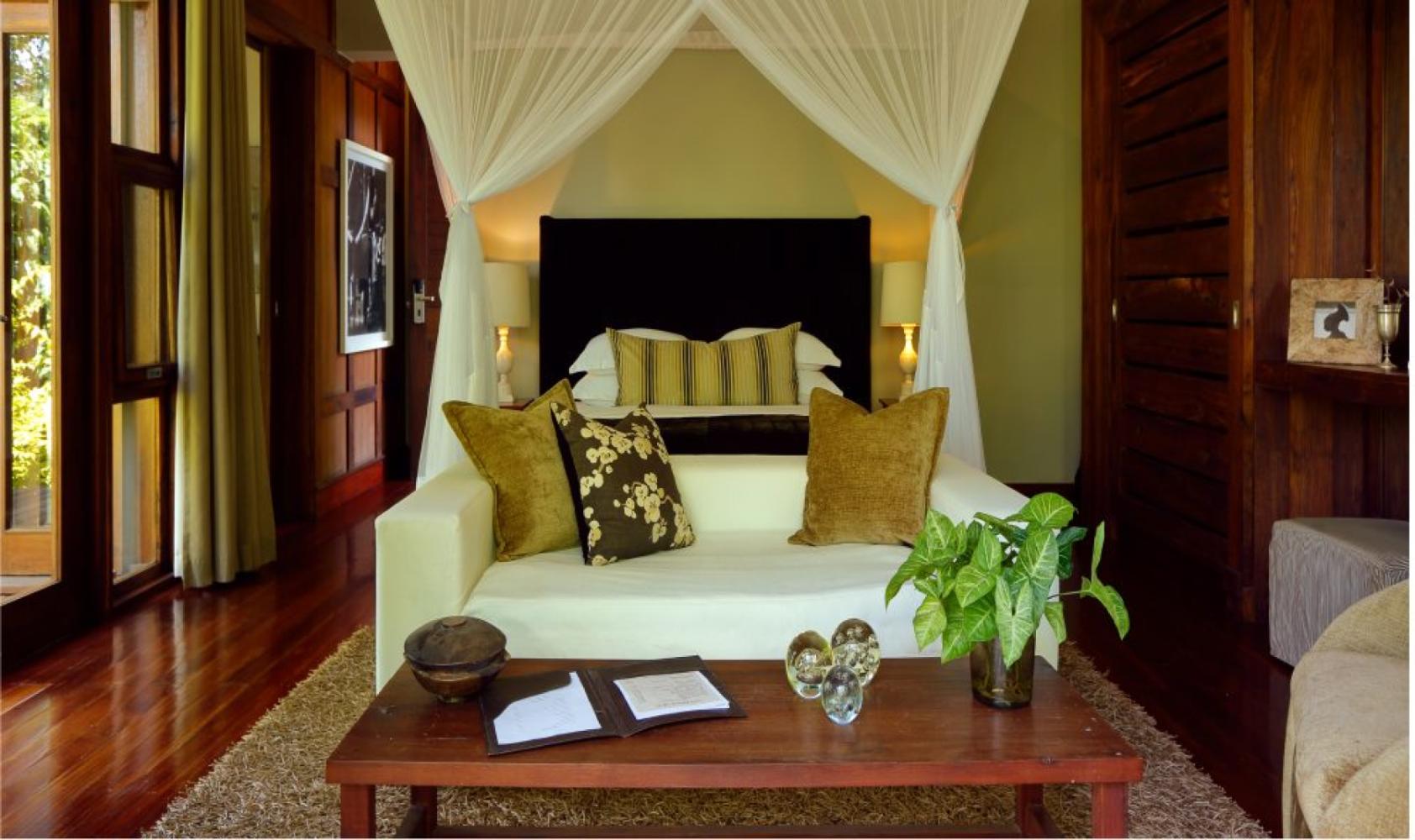 Chalet bedroom with canopy bed at Lake Duluti Lodge, Arusha