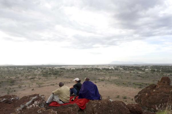 Guests with a Maasai guide on a hilltop in Enduimet