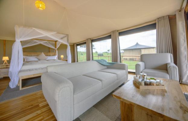 Tented suite with canopy bed and lounge at Lala Salama Serengeti Luxury Camp