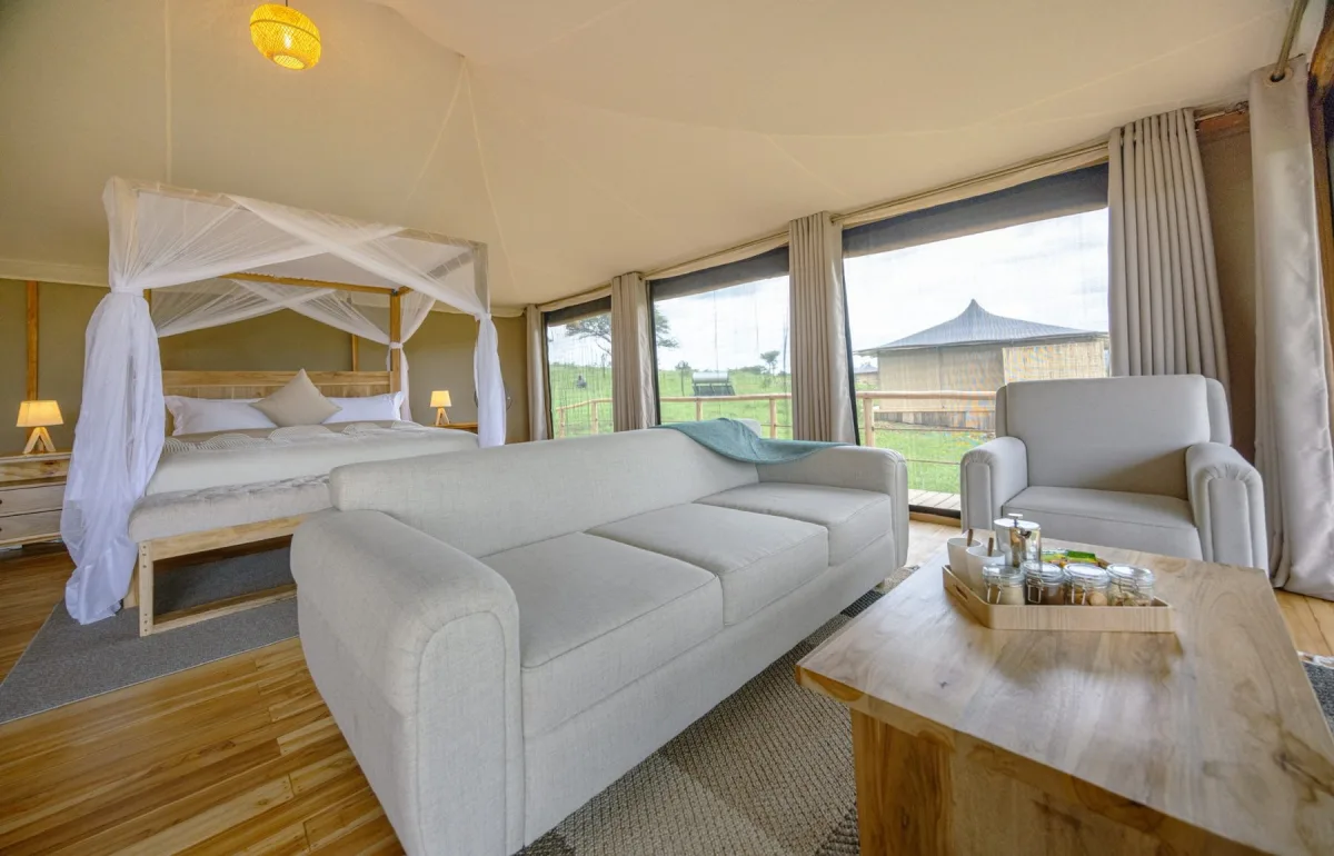 Tented suite with canopy bed and lounge at Lala Salama Serengeti Luxury Camp