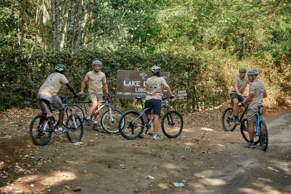 Radtour am Lake Duluti – Riders gathered at the Lake Duluti sign at the start of the forest trail