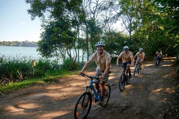 Radtour am Lake Duluti – Riders on the lakeside track with Lake Duluti behind them