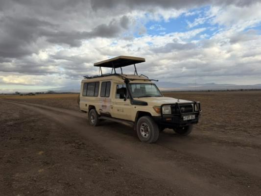 Radtour am West-Kilimandscharo – An Exceptional Safaries Land Cruiser on a dry plain under a big sky