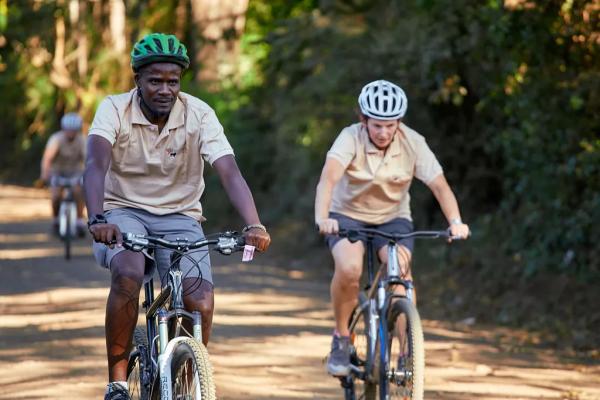 Riders on the shaded forest track of the Lake Duluti Forest Reserve