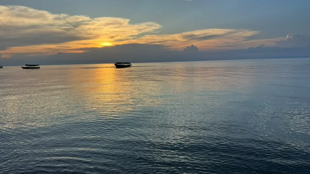 Gombe-Stream-Nationalpark – The sun setting over Lake Tanganyika with boats on the water
