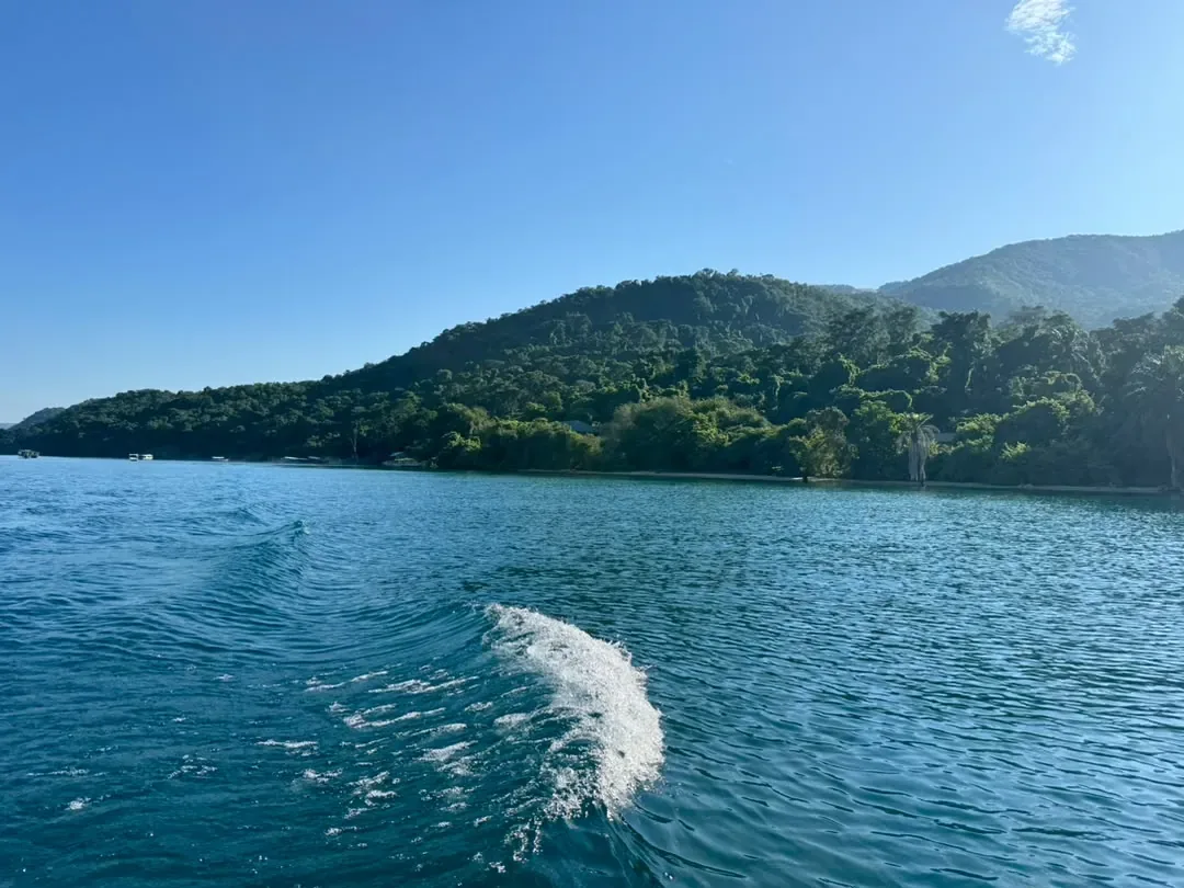 Gombe-Stream-Nationalpark – Speeding by boat along the green Gombe shoreline of Lake Tanganyika