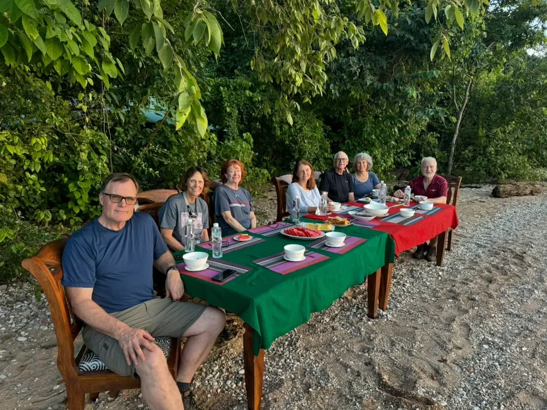 Gombe-Stream-Nationalpark – Guests at a table set on the pebble shore of Lake Tanganyika
