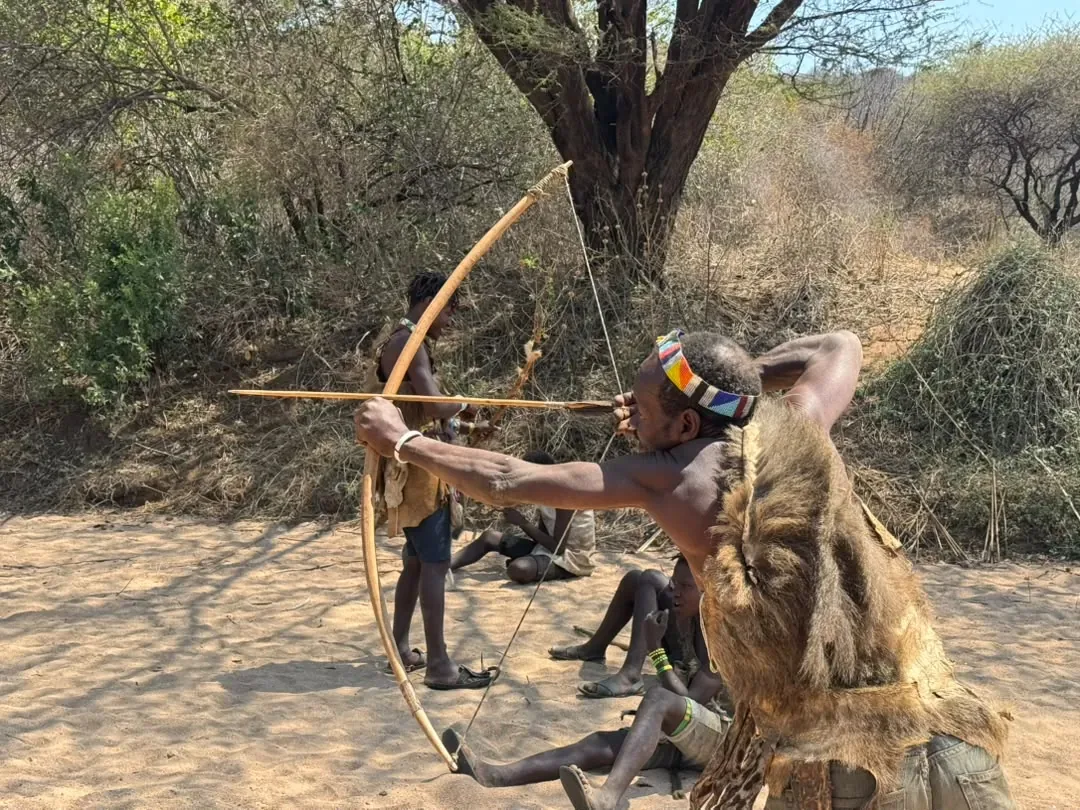 Lago Eyasi – A Hadzabe hunter in a hide cape drawing his bow