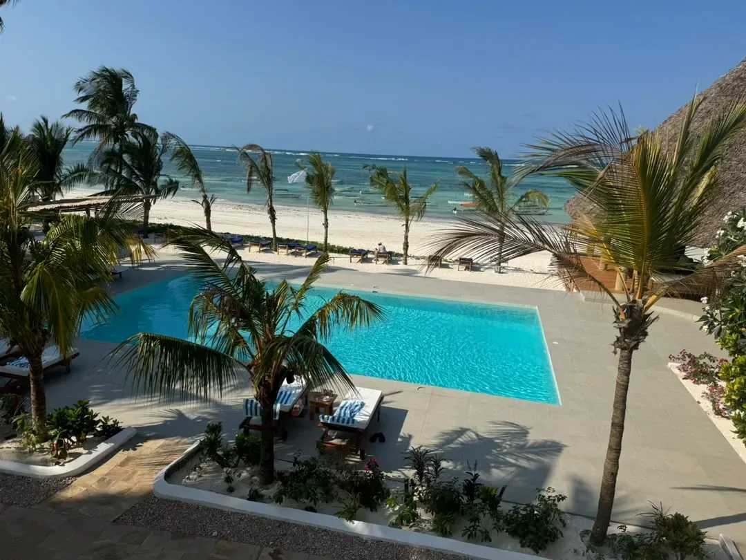 L’archipel de Zanzibar – A beach resort pool among palms beside the white Zanzibar sand