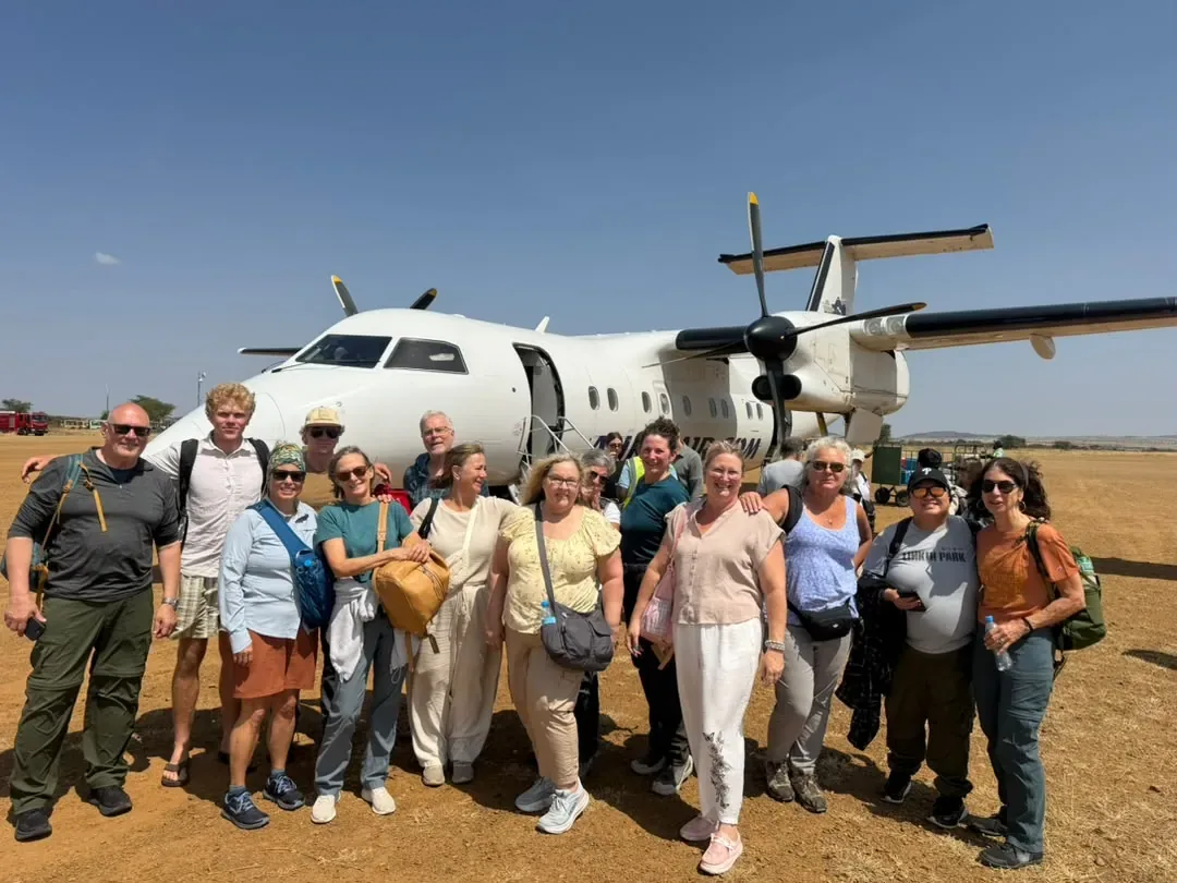 A group of guests in front of their light aircraft at the airstrip
